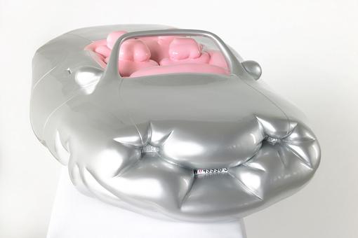 The photo shows a plastic that looks like an inflatable, thick convertible in the color silver, with four implied pink occupants