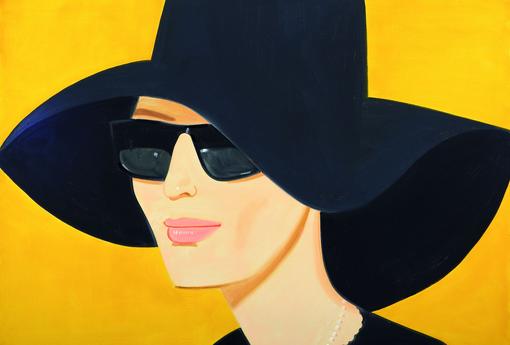 Portrait of woman with black wide brimmed hat and black sunglasses against yellow background