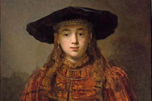 Das Foto zeigt einen Ausschnitt des Ölgemäldes Mädchen im Bilderrahmen von Rembrandt. Das Mädchen trägt ein braunes kostbares Samtgewand, langes braunes Haar und einen schwarzen Hut