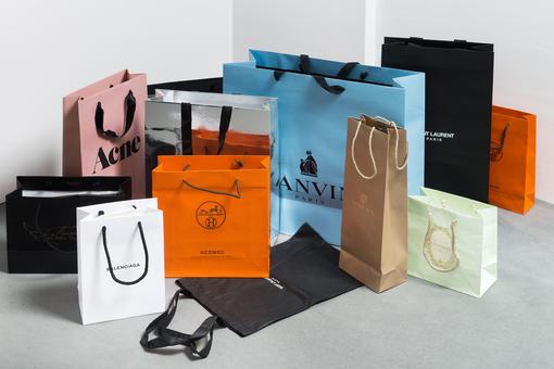A photo with different carrier bags of various luxury companies