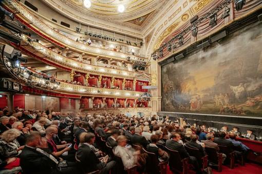You can see the interior of the Theater an der Wien with a view of the stage from the side, audience in the rows of seats
