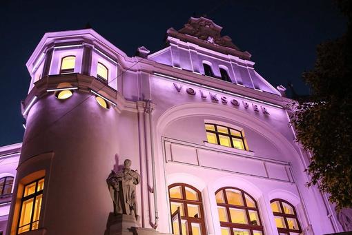 Volksoper with new façade and magenta-colored LED exterior lighting at night