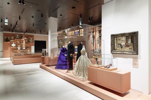 Exhibition view with exhibits from Vienna's Ringstrasse period: period clothing, paintings, busts, etc.