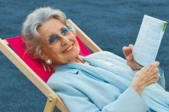 A photo of Lotte Tobisch lying in a deck chair and holding a book in her hand